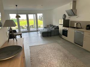 a kitchen and living room with a couch and a table at Hof Busen Landhaus Ap. in Mönchengladbach