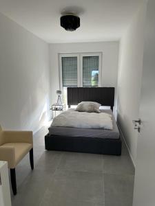 1 dormitorio con 1 cama y 1 silla en Hof Busen Landhaus Ap. en Mönchengladbach