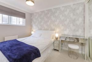 a bedroom with a white bed and a desk and a window at Jorvik Heights in York