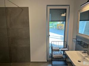 ein Badezimmer mit einer Dusche, einem Waschbecken und einer Glastür in der Unterkunft Hof Busen Landhaus Ap. in Mönchengladbach