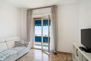 - un salon avec un canapé et une porte coulissante en verre dans l'établissement Margherita, à Ospedaletti