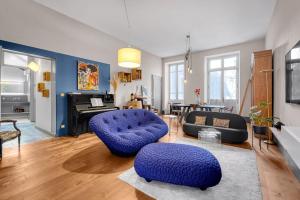 圖盧茲的住宿－Bleu du Maine - Elegant T3 avec terrasse，客厅配有2把蓝色椅子和钢琴
