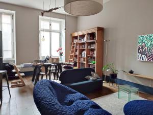 een woonkamer met een blauwe bank en een tafel bij Bleu du Maine - Elegant T3 avec terrasse in Toulouse