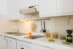 cocina blanca con fregadero y fogones en Stampa Flexyrent Apartment, en Milán