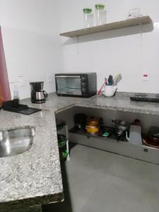 a kitchen with a counter top with a microwave at Loft Térreo no Centro in Búzios
