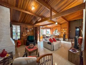 a living room with a couch and a table at Cantareira - Deck House in Mairiporã