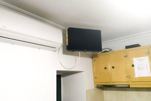 TV de pantalla plana en el techo de una habitación en Casa das Matriarcas - Casa da Avó Elisinha, en Belmonte