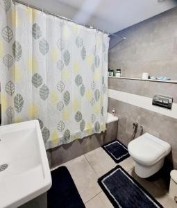 uma casa de banho com um WC e uma cortina de chuveiro em Apart haut standing v mer em Sousse