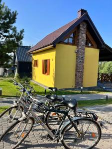 Brzozowe Wzgórze z jacuzzi i rowerami في ياستراوبيا جورا: مجموعة من الدراجات متوقفة أمام مبنى أصفر