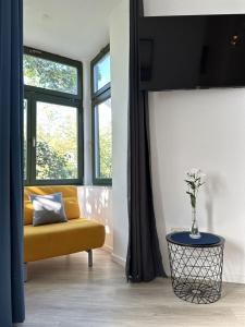 a living room with a yellow couch and two windows at City Center Leipzig II in Leipzig +36 photos