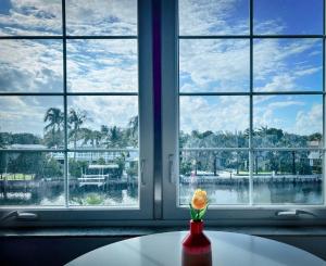a vase with a flower on a table in front of a window at South Beach Bayside in Miami Beach