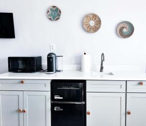 a kitchen with white cabinets and a black dishwasher at South Beach Bayside in Miami Beach
