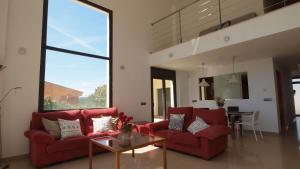 una sala de estar con 2 sofás rojos y una mesa. en Costacabana - Villa Macey en Lloret de Mar