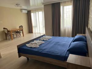 a bedroom with a bed with blue sheets and a table at villa with beautiful views in Tbilisi City