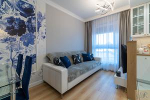 sala de estar azul y blanco con sofá en Apartament Rosa Stacja Mińsk, en Mińsk Mazowiecki