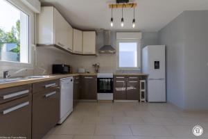 a kitchen with white appliances and a large window at Tri-O-Bois in Thianges