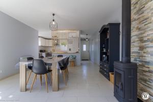 a kitchen and dining room with a wood stove at Tri-O-Bois in Thianges +18 photos