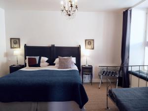 Un dormitorio con una cama grande y una lámpara de araña. en Maison Nº 20, en Eymet
