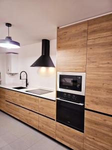 a kitchen with a stove and a sink and a microwave at apartamentcastrotuy in Tui