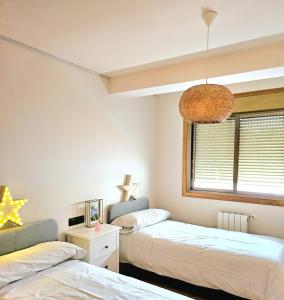1 dormitorio con 2 camas y lámpara de araña en apartamentcastrotuy, en Tui