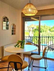 una mesa y sillas en una habitación con balcón en apartamentcastrotuy en Tui