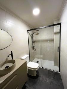 a bathroom with a shower and a toilet and a sink at apartamentcastrotuy in Tui +5 photos