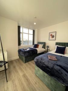 a bedroom with two beds and a window at Flitwick Luxury 3 Bedroom Apartment in Flitwick