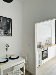 cocina blanca con mesa y encimera en City Center Leipzig II, en Leipzig