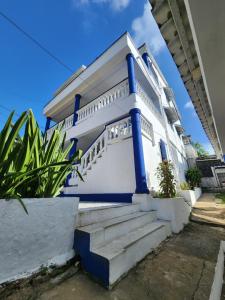 Casa blanca con columnas azules y escaleras en Apartamentos SurOeste, en San Andrés