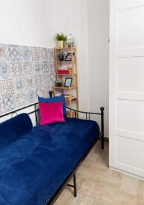 sypialnia z niebieskim łóżkiem i różową poduszką w obiekcie Fifteen Apartment w mieście Neapol