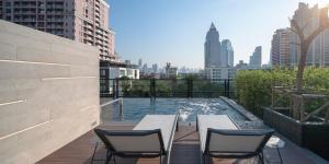 um pátio com cadeiras e uma piscina num edifício em PASSA Hotel Bangkok em Bangkok