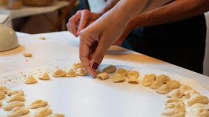 a woman is making food on a table at Palazzo Zacà in Gallipoli