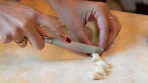 a person cutting up food on a cutting board with a knife at Palazzo Zacà in Gallipoli