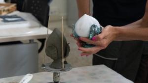 a woman is making a piece of pottery at Palazzo Zacà in Gallipoli