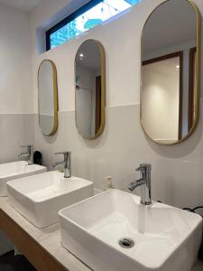 two sinks in a bathroom with two mirrors at Jiran Hostel Kota Kinabalu in Kota Kinabalu