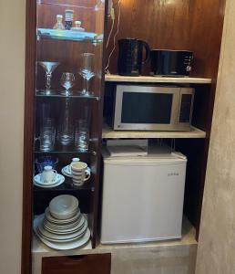 a cabinet with a microwave and some plates and cups at Simbiose in Carcavelos