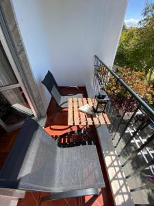 a balcony with a wooden table and a chair at Simbiose in Carcavelos