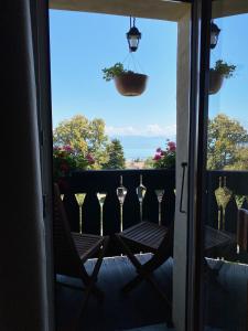a balcony with a table and wine glasses on it at BnB La Clemonie in Arzier