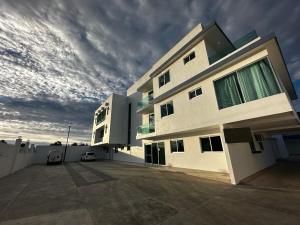 un grand bâtiment blanc avec un ciel nuageux dans l'établissement Casa Picacho by Cobo´s, à Aguascalientes
