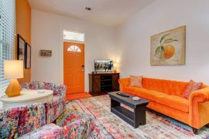 a living room with an orange couch and a table at Tangerine Bungalow Downtown Hot Springs in Hot Springs