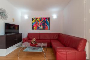 a red couch in a living room with a painting at Vila Snjezana in Trogir