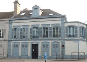 niebiesko-biały budynek z czarnymi drzwiami w obiekcie La Maison V.H., Appartements d'Hôtes w Troyes