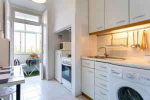 a kitchen with a sink and a washing machine at Principe Real Orange tree w/ view 3 bedrooms flat! in Lisbon