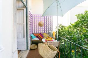 a balcony with a table and an umbrella at Principe Real Orange tree w/ view 3 bedrooms flat! in Lisbon