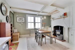 uma sala de jantar com uma mesa e uma lareira em Pass the Keys Perfectly presented centrally located townhouse em Royal Tunbridge Wells