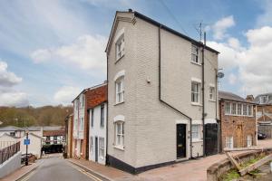 a white brick building on the side of a street at Pass the Keys Perfectly presented centrally located townhouse in Royal Tunbridge Wells
