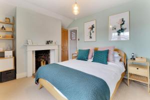 um quarto com uma cama com almofadas azuis e cor-de-rosa em Pass the Keys Perfectly presented centrally located townhouse em Royal Tunbridge Wells