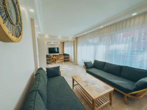 a living room with a green couch and a clock at Central, Spacious with Balcony & Elevator Flat in Beşiktaş in Istanbul