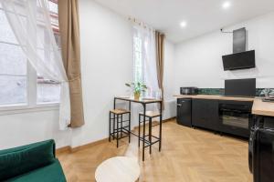 a kitchen with a green couch and a table at Le Verdoyant - T2 moderne - proche Gare in Toulouse