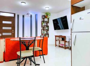 eine Küche mit einem Tisch und Stühlen sowie einem Kühlschrank in der Unterkunft Casa Linda in Puyo